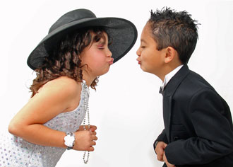 Children dressed as bride and groom kissing