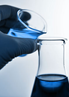 Poring blue liquid in laboratory
