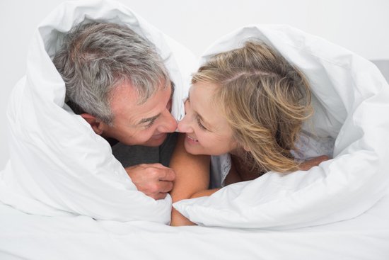 Happy intimate couple in bed